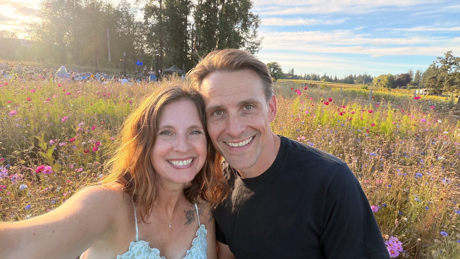 Jarod and Rachel smiling together in a sunlit flower field